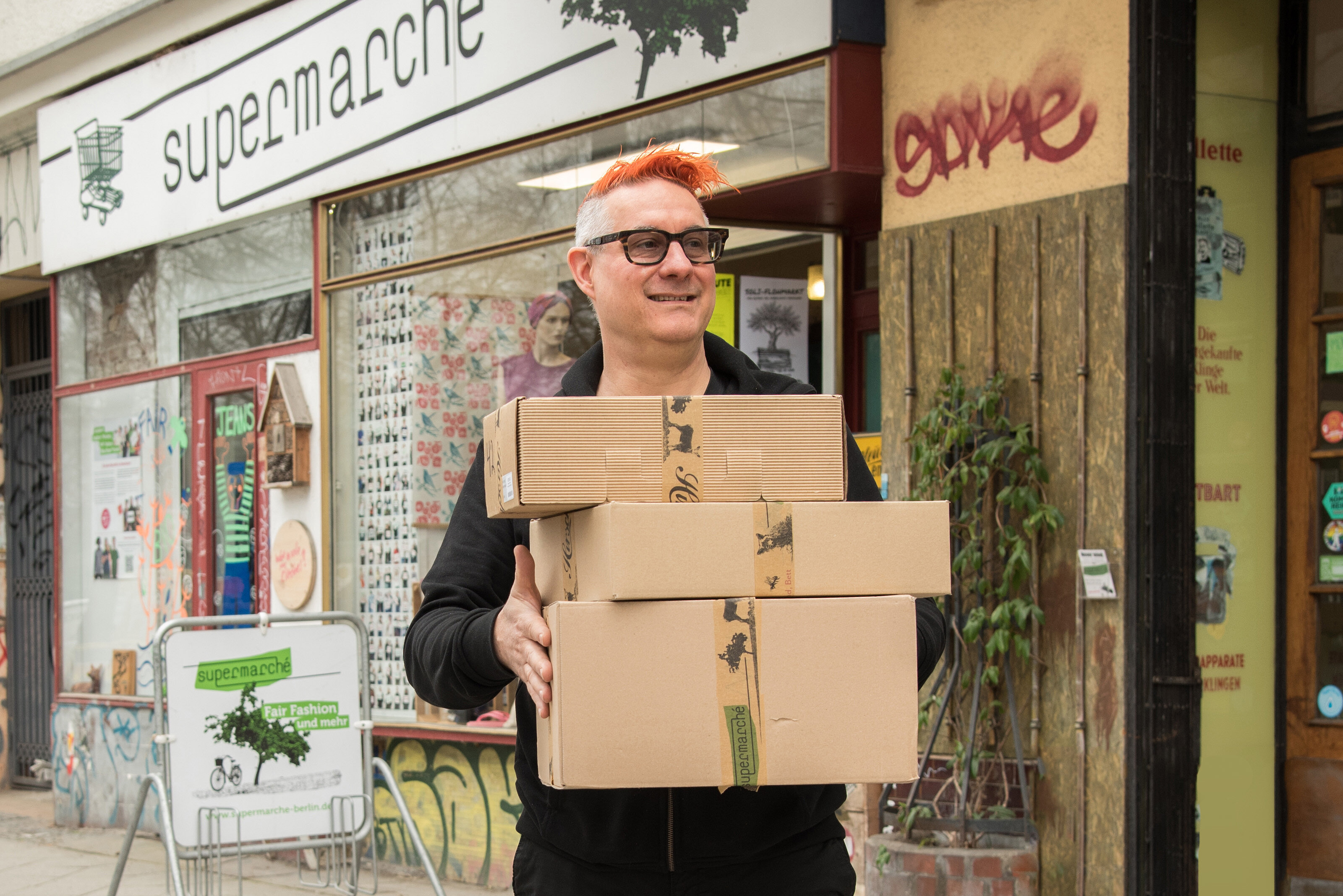 Inhaber Ben mit Paketen vor dem supermarché auf dem Weg zum Post-Späti