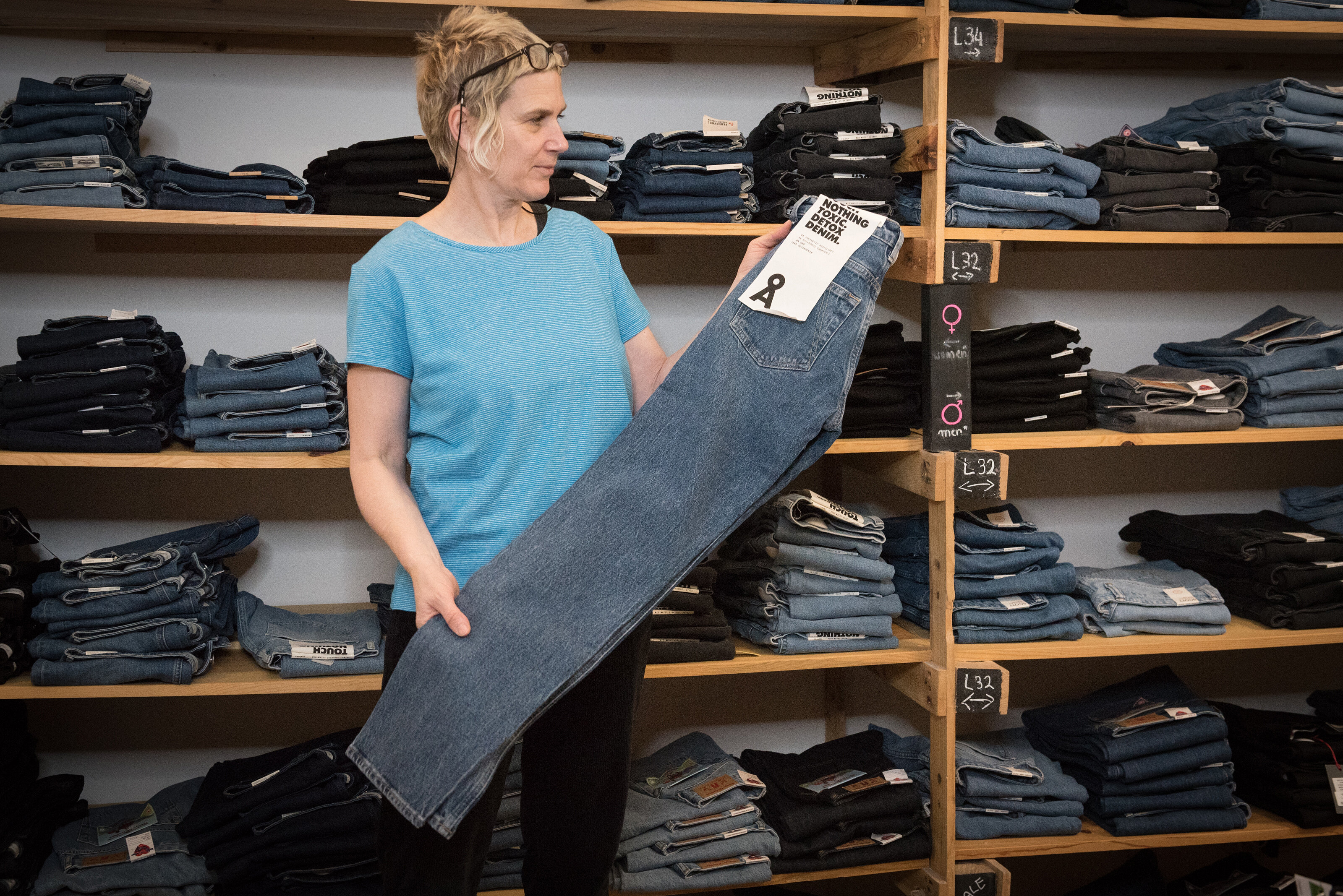 Inhaberin Nici mit einer Jeans vor dem Jeansregal