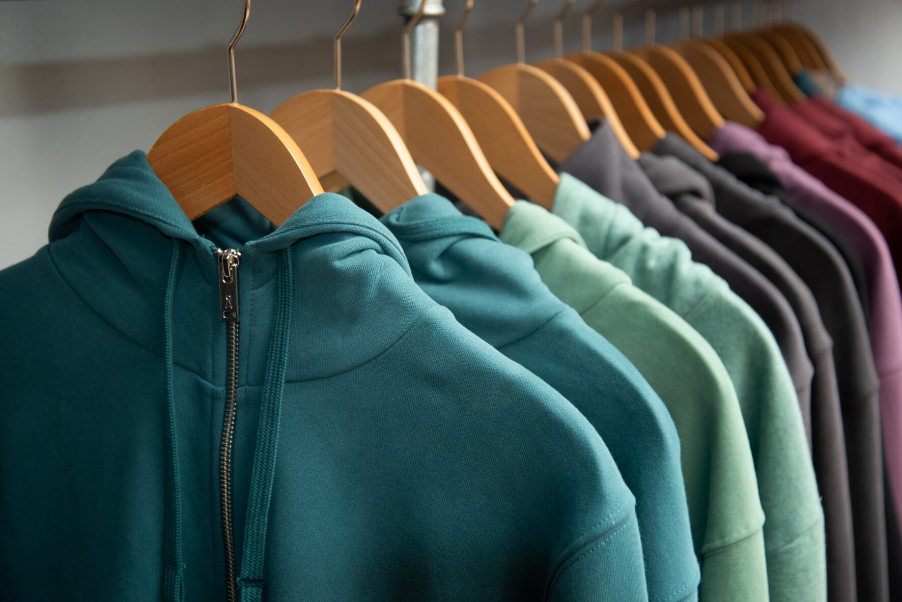 Hoodies in verschiedenen Farben hängen auf der Stange